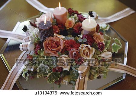 Stock Photograph - Centrepiece with candles, roses and ribbon. Fotosearch