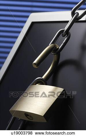 Stock Photo - Chain and padlock on computer monitor, close up. Fotosearch