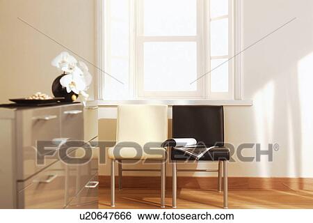 Chairs Under Window And Flowers On Dresser Stock Photograph