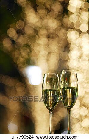 Picture - Champagne glasses in front of fairy lights. Fotosearch