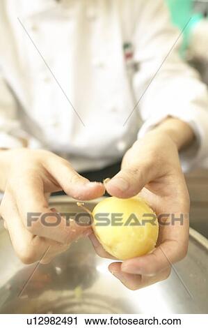 Stock Image - Chef Peeling Potatoes with his Hands. Tokyo Prefecture, Japan. Fotosearch