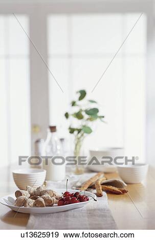 Stock Photo - Cherries and breadsticks on a kitchen countertop. Fotosearch
