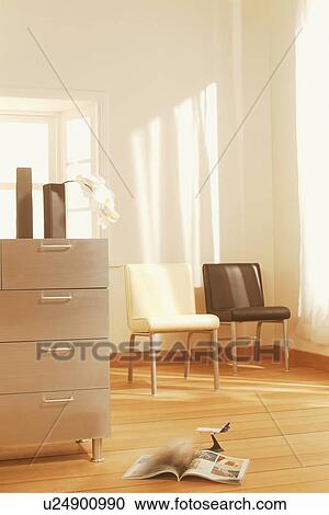 Stock Image - Chest of drawers in living room with chairs. Fotosearch