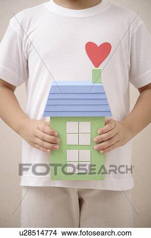 Picture - Child holding a house with heart shape. Fotosearch