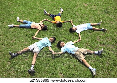 Children lying on field holding hands. Futako-tamagawa, Setagaya-ku, Tokyo Prefecture, Japan View Large Photo Image Stock Photography - Children lying on field holding hands. Futako-tamagawa, Setagaya-ku, Tokyo Prefecture, Japan. Fotosearch