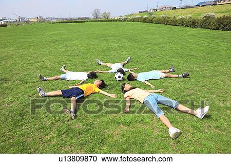 Children lying on field with soccer ball. Futako-tamagawa, Setagaya-ku, Tokyo Prefecture, Japan View Large Photo Image Stock Image - Children lying on field with soccer ball. Futako-tamagawa, Setagaya-ku, Tokyo Prefecture, Japan. Fotosearch