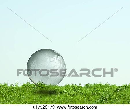 Stock Photo - Clear Globe Floating Above Green Field. Fotosearch