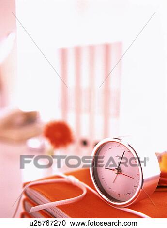 Clock on stack of orange notebooks View Large Photo Image Stock Image - Clock on stack of orange notebooks. Fotosearch