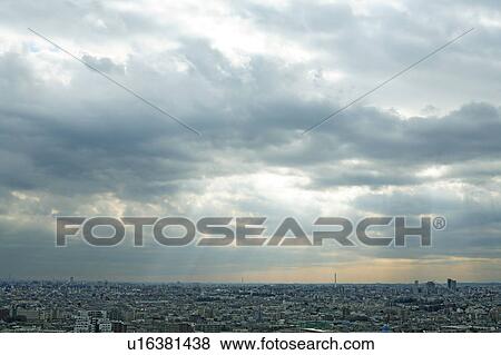 Stock Photo - Clouds and sunbeams over city, Tokyo prefecture, Japan. Fotosearch