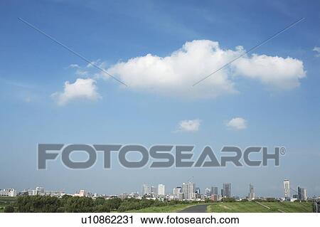 Stock Image - Clouds over office buildings, Tokyo prefecture, Japan. Fotosearch