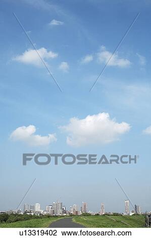 Stock Image - Clouds over office buildings, Tokyo prefecture, Japan. Fotosearch