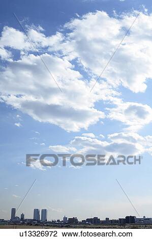 Stock Image - Clouds over office buildings, Tokyo prefecture, Japan. Fotosearch