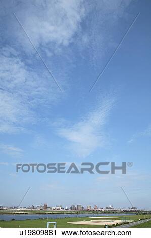 Stock Image - Clouds over office buildings, Tokyo prefecture, Japan. Fotosearch