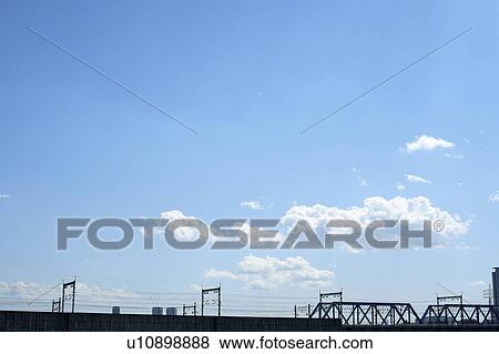 Stock Photo - Clouds over railroad bridge, copy space, Tokyo prefecture, Japan. Fotosearch