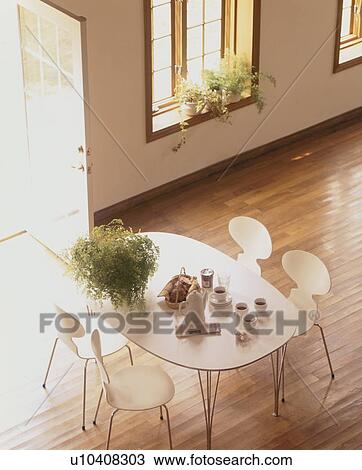 Stock Image - Coffee and muffins on white table with chairs. Fotosearch