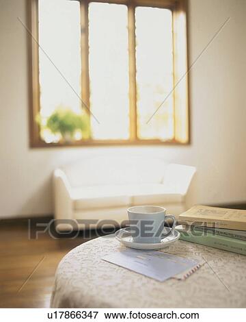 Stock Photo - Coffee cup on a table with books and mail. Fotosearch