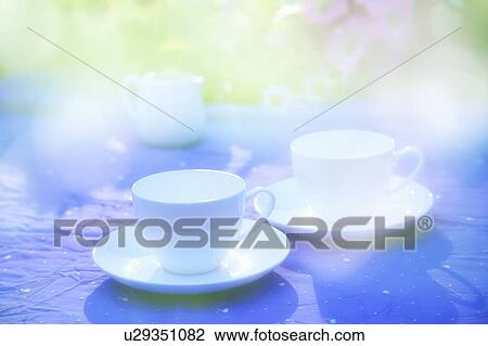 Stock Image - Coffee cups on blue tablecloth. Fotosearch