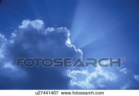 Stock Photo - Crepuscular rays from behind clouds. Fotosearch