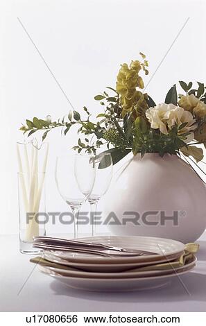 Stock Photograph - Crockery and glassware with a vase of flowers. Fotosearch