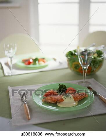 Stock Photograph - Crumbed fish with white sauce and vegetables. Fotosearch