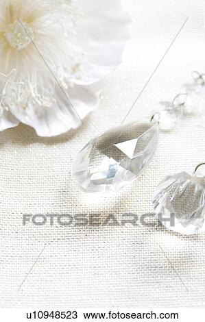Stock Image - Crystal drop decoration and a decorative white flower. Fotosearch