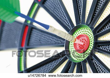 Dart and dartboard, dart in bull's-eye, close up View Large Photo Image Picture - Dart and dartboard, dart in bull's-eye, close up. Fotosearch