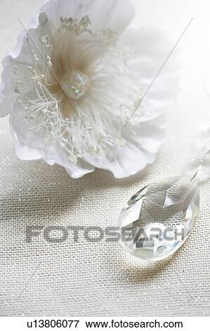 Stock Photo - Decorative flower and crystal on shiny white fabric. Fotosearch