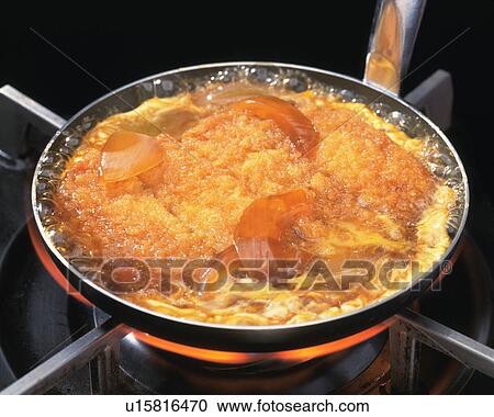 Stock Image - Deep fried pork being cooked in pan. Fotosearch