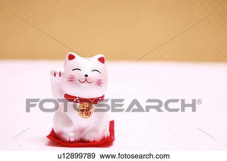 Stock Photo - Doll of cat with a beckoning paw. Fotosearch