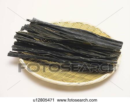 Stock Image - Dried kelp on colander, white background. Fotosearch