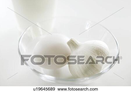 Stock Photo - Egg and garlic in a glass bowl. Fotosearch