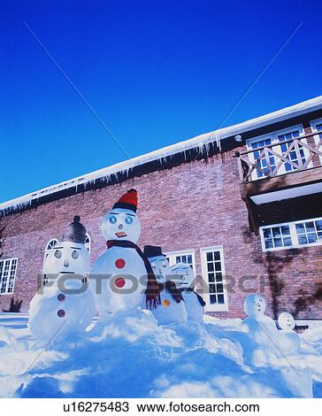 Stock Image - Family of snowmen in the yard. Fotosearch