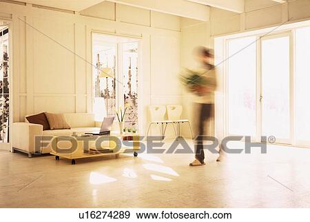 Figure walking in sunny living room View Large Photo Image Stock Photo - Figure walking in sunny living room. Fotosearch