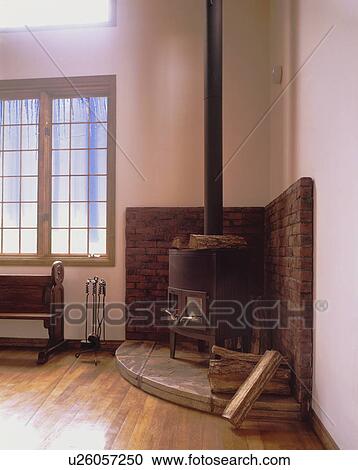 Stock Image - Fireplace and pew wooden floored room. Fotosearch