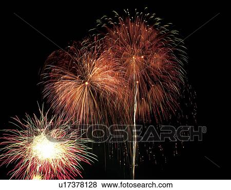 Stock Photo - Fireworks exploding in sky, black background, long exposure. Fotosearch