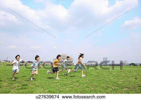 Picture - Five children running on field. Futako-tamagawa, Setagaya-ku, Tokyo Prefecture, Japan. Fotosearch