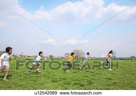 Stock Photo - Five children running on field. Futako-tamagawa, Setagaya-ku, Tokyo Prefecture, Japan. Fotosearch