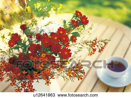 Stock Image - Flower arrangement on a table with a cup of coffee. Fotosearch