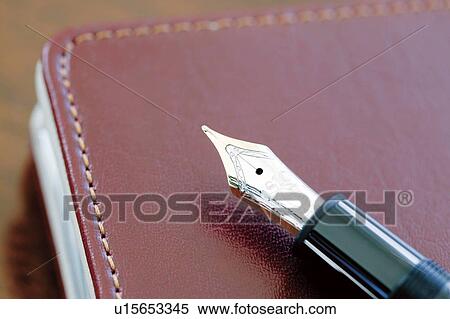 Stock Photography - Fountain pen on a leather bound notebook. Fotosearch