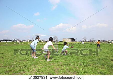 Four children playing soccer near goal posts. Futako-tamagawa, Setagaya-ku, Tokyo Prefecture, Japan View Large Photo Image Stock Image - Four children playing soccer near goal posts. Futako-tamagawa, Setagaya-ku, Tokyo Prefecture, Japan. Fotosearch
