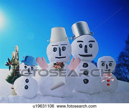 Stock Photograph - Four snowmen in the snow ay Christmas time. Fotosearch