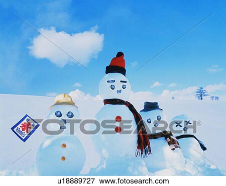 Stock Photo - Four snowmen with a small flag in the snow. Fotosearch