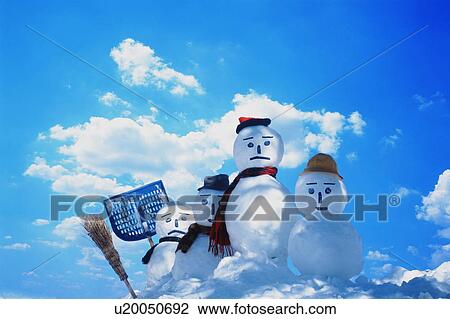 Stock Image - Four snowmen with tools in the snow. Fotosearch