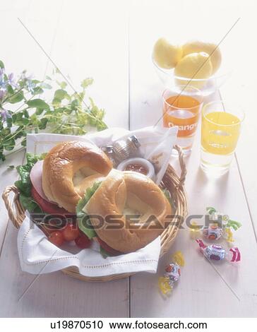 Stock Image - Fresh bagels with salad, lemons and sweets. Fotosearch