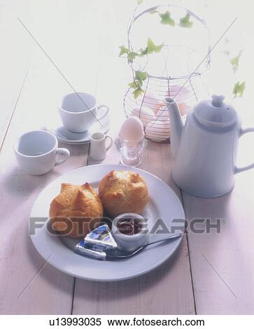 Stock Photography - Fresh scones and coffee on a table with eggs. Fotosearch