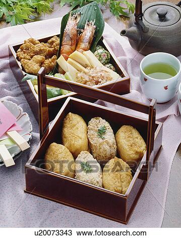 Stock Image - Fried bean curds stuffed with rice in box. Fotosearch