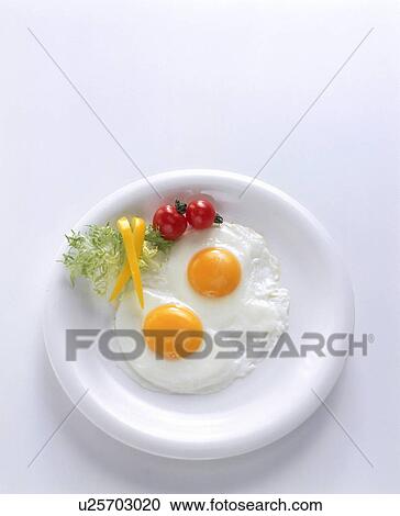 Stock Image - Fried eggs with salad garnish. Fotosearch