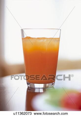 Stock Image - Glass of carrot juice on table. Fotosearch
