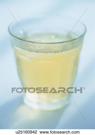 Stock Image - Glass of iced tea, blue background. Fotosearch
