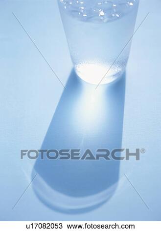 Glass of water being reflected on blue background View Large Photo Image Stock Image - Glass of water being reflected on blue background. Fotosearch